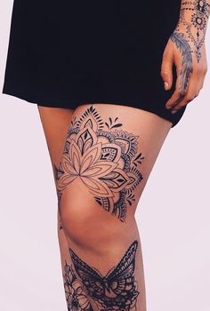 a woman with tattoos on her legs and thigh is standing in front of the camera