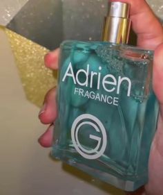 someone is holding a bottle of perfume in their hand and it says adriennfragance