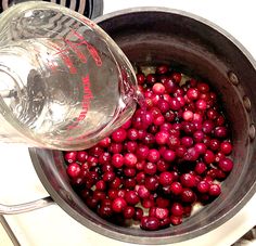 cranberries are being mixed in a pot with water to make them taste good