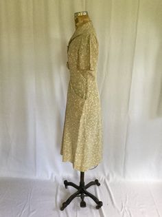 "Vintage 1940s Cage latte colored rayon green and white floral day dress Vneck with wide point collar Two tabs on bodice front with green white floral buttons for trim Short sleeves Metal side zipper for closure Fitted waist 2 pockets Aline skirt MEASUREMENTS : Fits like a small Shoulders: 14.5\" Bust: 38\" Waist: 26\" Hips: up to 36\" Sleeve length: 9\" Sleeve opening: 6.25\" diameter Length: 43\" Brand/Label: None Condition: Excellent Stay in touch: Instagram @beeandmason Facebook Bee & Ma 1950s Collared Daywear Dresses, 1950s Collared Day Dresses, Vintage Green Collared Dress, Beige Vintage Dress For Garden Party, Vintage Collared Beige Dresses, Vintage Beige Collared Dress, Shirtwaist Dress, Aline Skirt, 1920s Dress