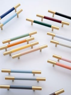 several different colored wooden handles on white surface