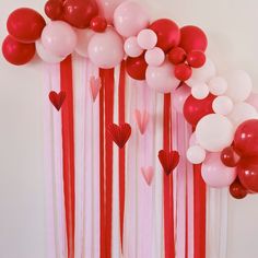 balloons and streamers are arranged in the shape of hearts