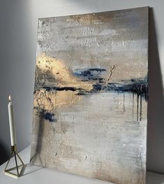 an abstract painting on canvas with a candle next to it