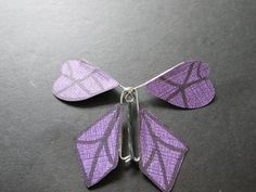 the purple butterfly is made out of metal and has two wings that are attached to it