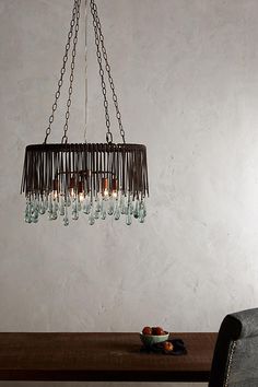 a chandelier hanging from the ceiling over a table