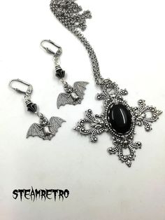 "This fantastic silver plated filigree cross necklace features a Swarovski black jet crystal and is part of our new Dark Gothic range, and is a step away from our previous steampunk work.The set comes complete with our spooky silver plated vampire bat earrings! There are numerous Gothic designers out there, and various marketplaces to purchase Gothic jewellery, but i am sure you will like what we are doing here Growing up in the 80's i lived through the \"goth\" movement, many a lost weekend was Silver Cross Jewelry For Halloween, Black Cross Metal Earrings, Black Cross Jewelry For Halloween, Gothic Cross Pendant Jewelry Gift, Gothic Antique Silver Jewelry For Gift, Gothic Metal Jewelry With Filigree, Gothic Cross Jewelry For Gifts, Gothic Cross Jewelry As Gift, Gothic Cross Jewelry Gift