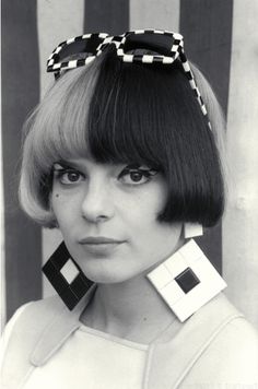 a black and white photo of a woman with short hair wearing an unusual head piece