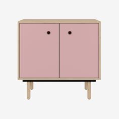 a pink cabinet sitting on top of a wooden table next to a white wall and floor