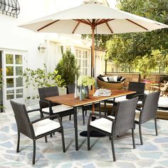 an outdoor dining table and chairs with an umbrella