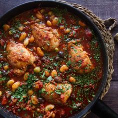 chicken and chickpeas stew in a skillet with garnishes on the side