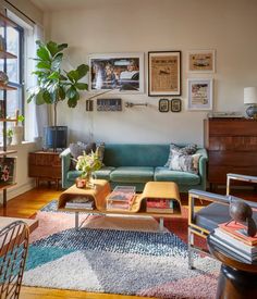 a living room filled with furniture and pictures on the wall above it's windows