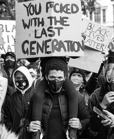 black and white photograph of protestors holding signs with words you faced with the last generation