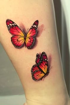 two red and yellow butterflies on the side of a woman's right leg,