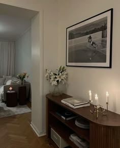 a living room filled with furniture next to a bed and a table topped with candles