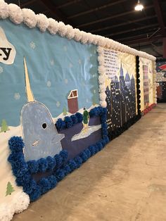 a wall decorated with blue pom poms and an image of a whale