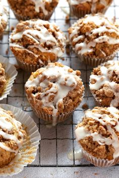 muffins with white icing sitting on a cooling rack