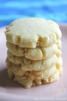 a stack of cookies sitting on top of a pink plate next to a blue table cloth