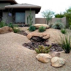 a house with rocks and plants in the front yard