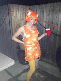 a woman in an orange costume holding a cup