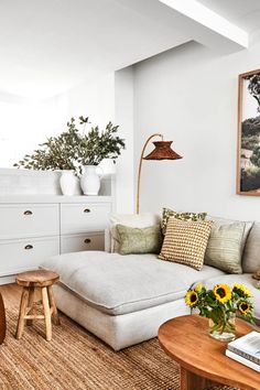 a living room with white furniture and sunflowers