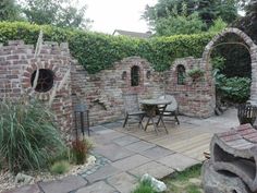 an outdoor dining area with brick walls and chairs