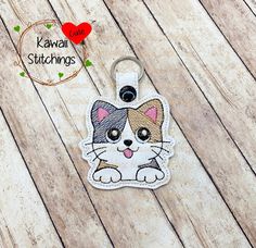 a keychain with a cat on it sitting on top of a wooden table