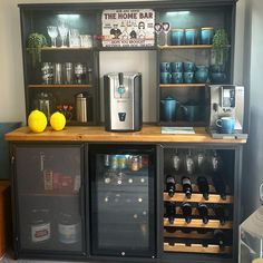 a wine bar with lots of bottles and glasses on the top shelf next to it