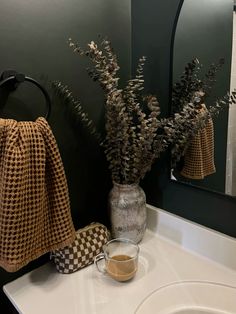 a bathroom sink with a towel and vase on it