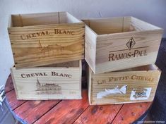 three wooden boxes sitting on top of a table next to a metal container with the words cheval blanc