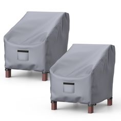 two gray covers sitting next to each other on top of wooden legs and one is closed