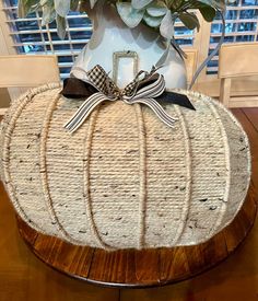 a white pumpkin shaped planter sitting on top of a wooden table