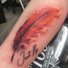 a red feather with the word just fly on it's left arm and an ink pen