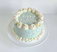 a blue birthday cake with white frosting and sprinkles