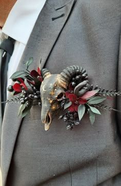 a man wearing a suit and tie with an animal skull on it's lapel