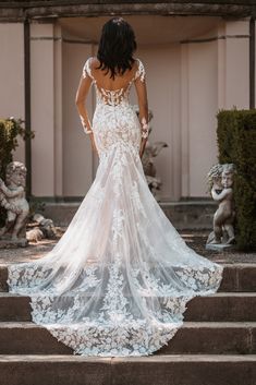 a woman in a wedding dress standing on some steps