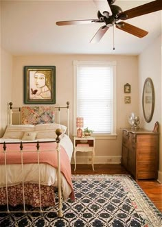 a bed room with a neatly made bed and a ceiling fan