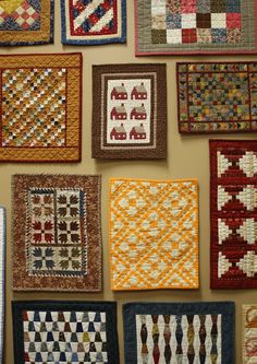 many different quilts are hanging on the wall