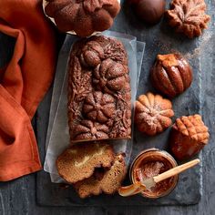 a loaf of bread sitting on top of a cutting board next to other baked goods