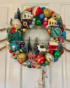 a christmas wreath with ornaments hanging from it's side on the front door,