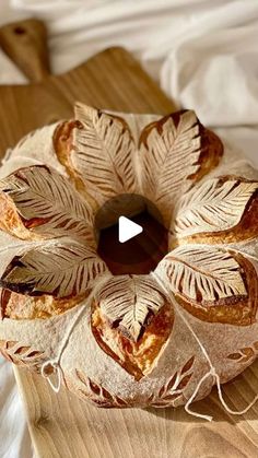 a video demonstrating how to make an artisan round bread with leaves on the top