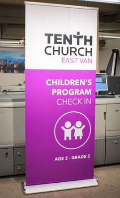 a purple sign that says children's program check in next to an office desk