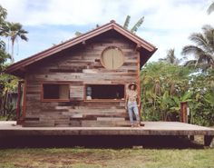 a man standing in front of a wooden cabin