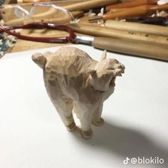 an animal figurine sitting on top of a table next to scissors and pencils