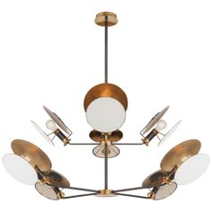 a brass chandelier with five lights hanging from the ceiling and four white shades