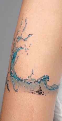 a woman with a tattoo on her arm has a sailboat in the water and splashing