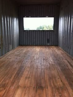 an empty room with wooden floors and walls