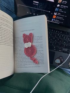 an open book with a crocheted teddy bear on it