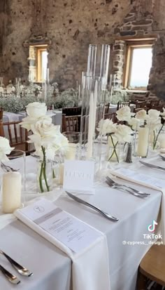 the tables are set with white flowers and silverware