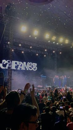 a group of people standing on top of a stage with their hands in the air