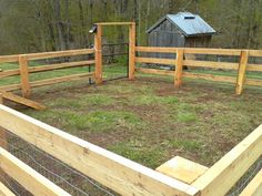 a fenced in area with grass and wooden posts